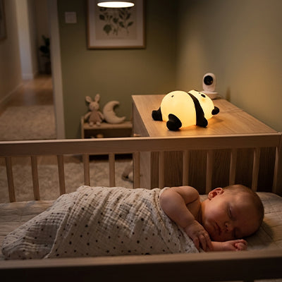 Veilleuse bébé panda allongée diffusant une lumière douce la nuit