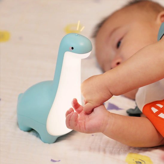 Veilleuse bébé dinosaure bleue au chevet du nourrisson